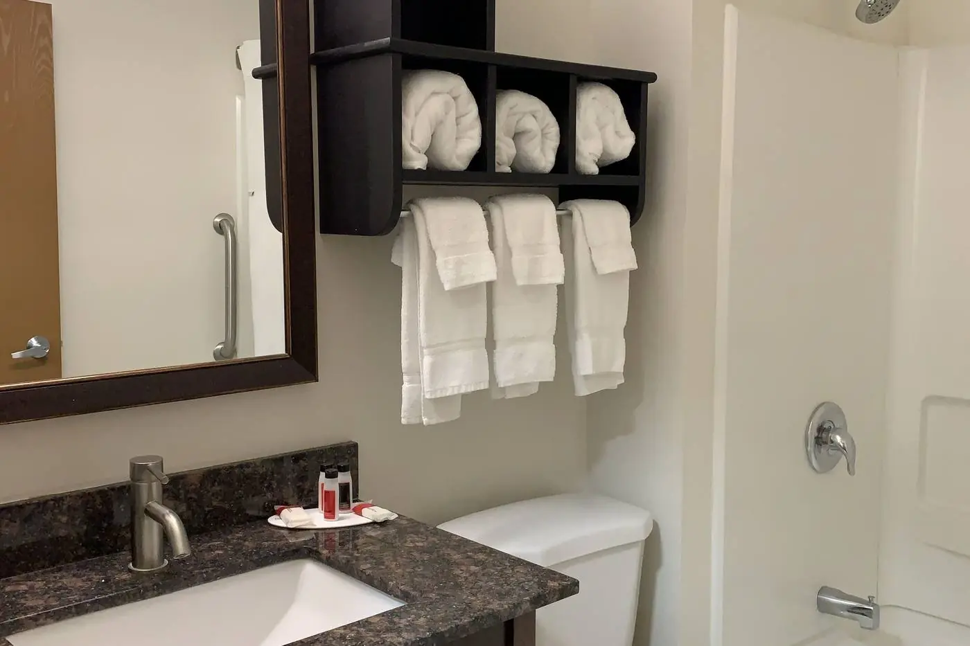 Guest bathroom with granite vanity and towel shelf